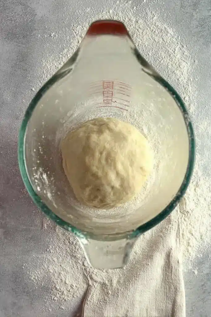 Pizza dough in a bowl ready to rise for Halloween ghost pizza