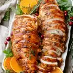 Roast Turkey Breast Recipe | Juicy & Easy Holiday Favorite 8 Sliced roast turkey breast with orange slices and rosemary on a platter
