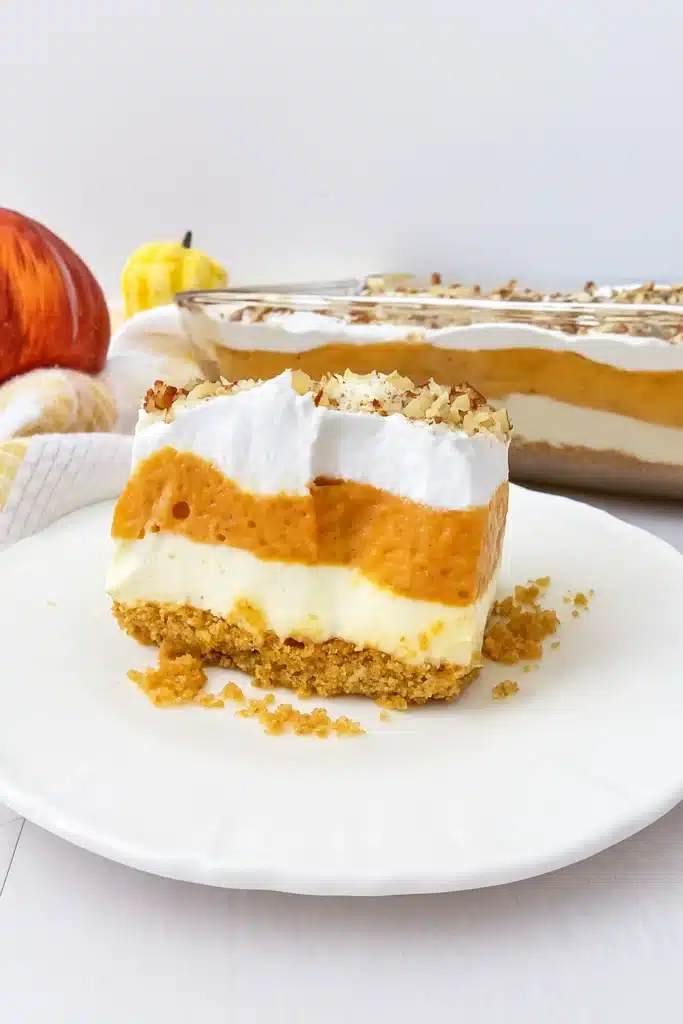 Pumpkin lush dessert slice with layered pumpkin, cream cheese, and whipped topping