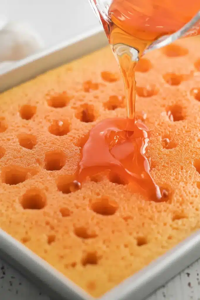 Orange Creamsicle Cake Recipe – Simple & Refreshing Treat 25 Pouring orange creamsicle filling into cake holes