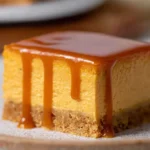 The Best Pumpkin Cheesecake Bars Ever with caramel drizzle on white plate