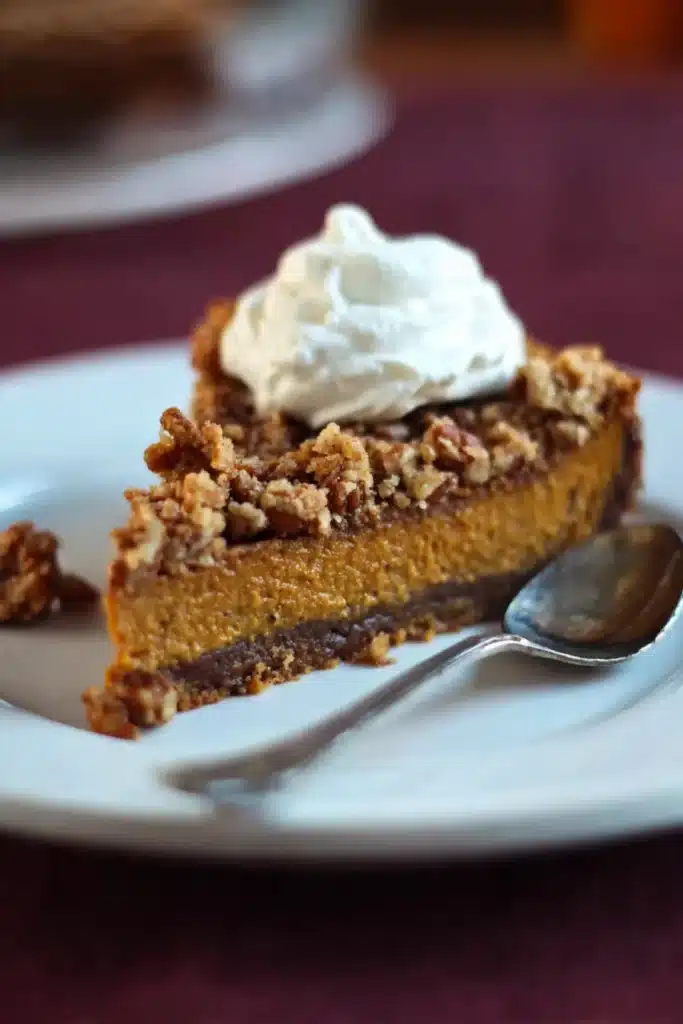 Slice of pumpkin pecan streusel torte with whipped cream on top