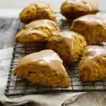 Freshly baked pumpkin scones with spiced glaze on a cooling rack