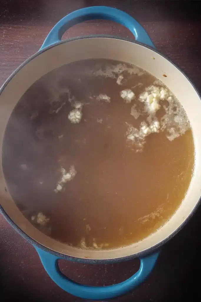 Quick & Easy Wonton Soup broth simmering in a Dutch oven