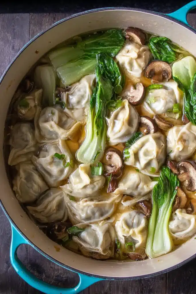 Quick & Easy Wonton Soup simmering with dumplings, bok choy, and mushrooms