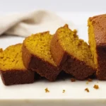 Pumpkin Bread – Rich, Moist & Irresistible Fall Favorite 12 Slices of rich and buttery pumpkin bread on a ceramic serving tray