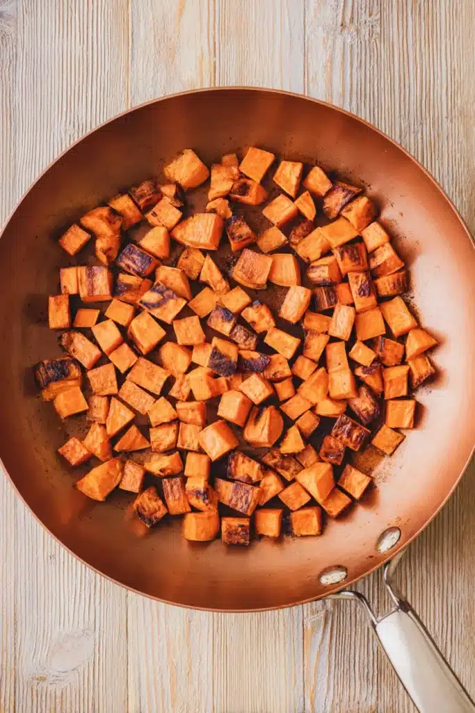 Crispy seared sweet potatoes in skillet for breakfast hash