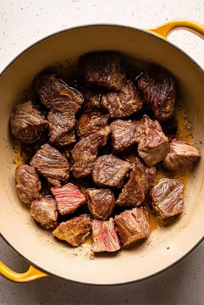 Classic Beef Bourguignon – Cozy, Delicious Holiday Favorite 15 Seared beef chunks in Dutch oven for classic beef bourguignon