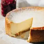 Classic New York Cheesecake Recipe – Foolproof & Delicious 24 Classic New York cheesecake sliced with powdered sugar and berry compote