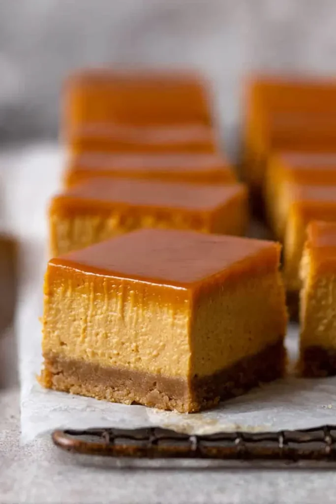 The Best Pumpkin Cheesecake Bars Ever sliced with caramel topping