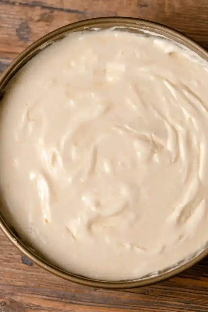 Smooth sugar cookie cheesecake batter in pan ready to bake