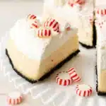 Slice of white chocolate peppermint cheesecake with whipped cream and crushed candy canes