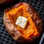 Air fryer baked sweet potato with butter and pepper on top