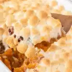 Sweet Potato Casserole with Marshmallows being served from a baking dish