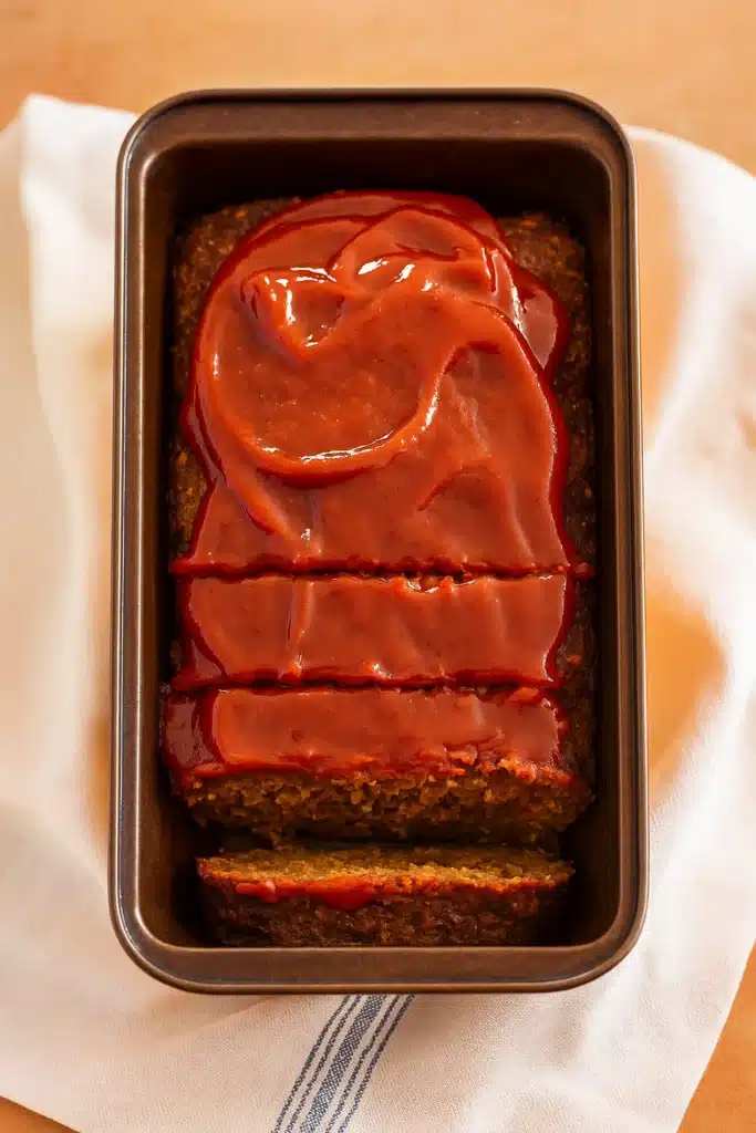 Vegetarian meatloaf in a loaf pan topped with glossy ketchup glaze