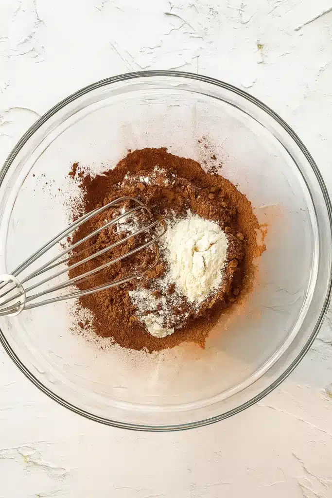 Mixing cocoa powder and flour in a glass bowl for easy Christmas brownies