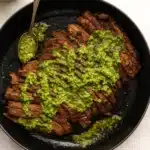 Chimichurri Flank Steak | Juicy & Bold Dinner Recipe 10 Chimichurri flank steak in skillet topped with green herb sauce