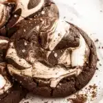 Chocolate marshmallow swirl cookies on a white plate with gooey melted marshmallow