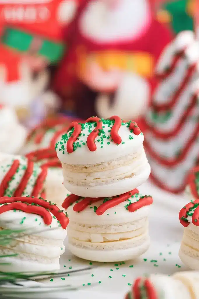 Christmas Tree Cake Macarons with red frosting drizzle and green sprinkles