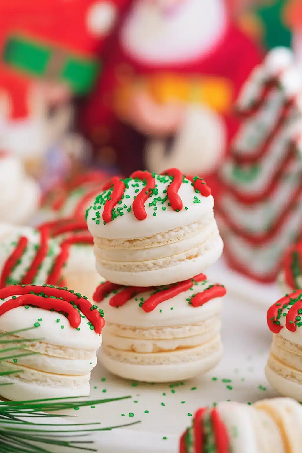 Christmas Tree Cake Macarons with red frosting drizzle and green sprinkles