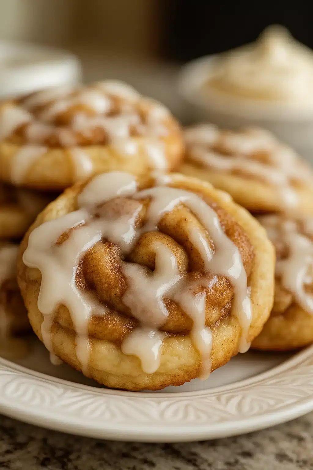 Close-up of cinnamon roll cookies with icing on white plate