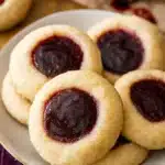 Classic Thumbprint Cookies – Easy, Sweet & Irresistible 12 Classic thumbprint cookies with raspberry jam filling on a plate
