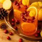 Cranberry orange prosecco punch with oranges and cranberries in festive fall setting