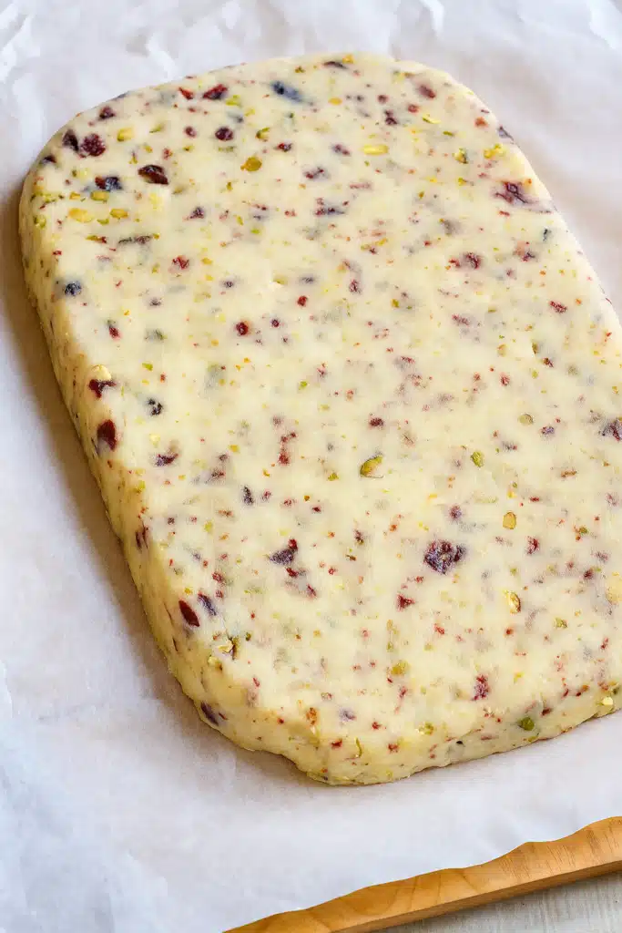 Cranberry pistachio shortbread dough block on parchment paper