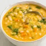 The Best White Bean Soup | Amazing Comfort Recipe 10 The Best White Bean Soup with carrots, spinach, and olive oil on a white-gray table