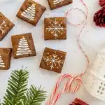 Easy Christmas brownies with icing snowflakes and tree designs on a holiday table