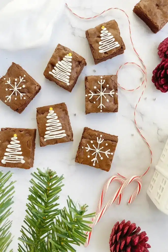 Easy Christmas brownies with icing snowflakes and tree designs on a holiday table