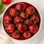Cranberry Meatballs Recipe – Sweet, Quick & Festive Favorite 13 Cranberry meatballs served in a white bowl with festive holiday decorations