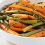 Flavorful roasted carrots and green beans with honey glaze in white bowl