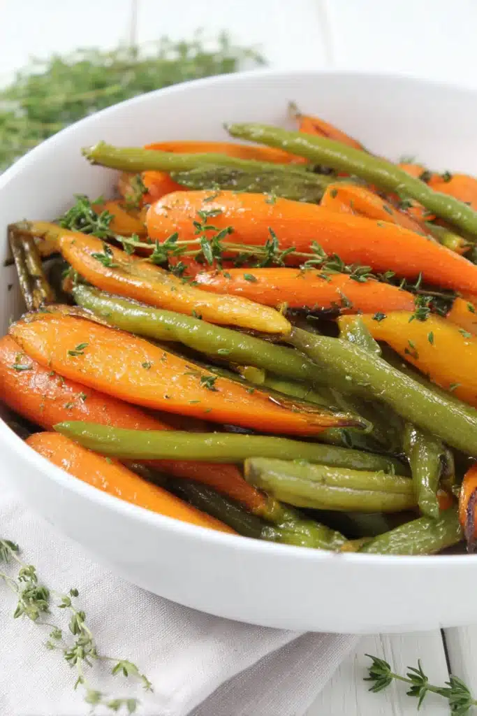 Flavorful roasted carrots and green beans with honey glaze in white bowl