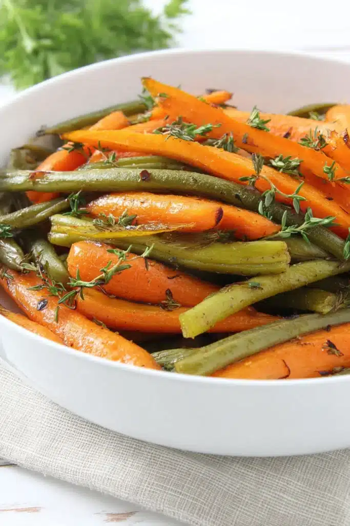 Flavorful roasted carrots and green beans with honey glaze in white bowl