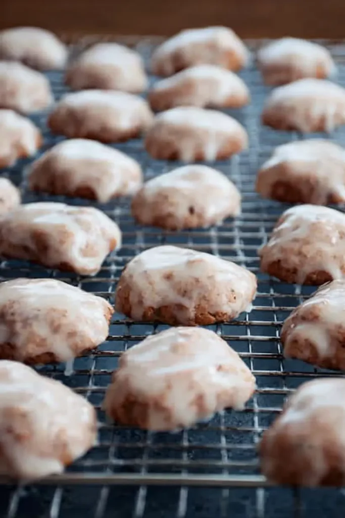 Irresistible Glazed Orange Cookies with Cinnamon & Cloves 9 freshly glazed orange cookies with cinnamon and cloves on cooling rack
