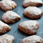 Irresistible Glazed Orange Cookies with Cinnamon & Cloves 12 glazed orange cookies with cinnamon and cloves on dark slate