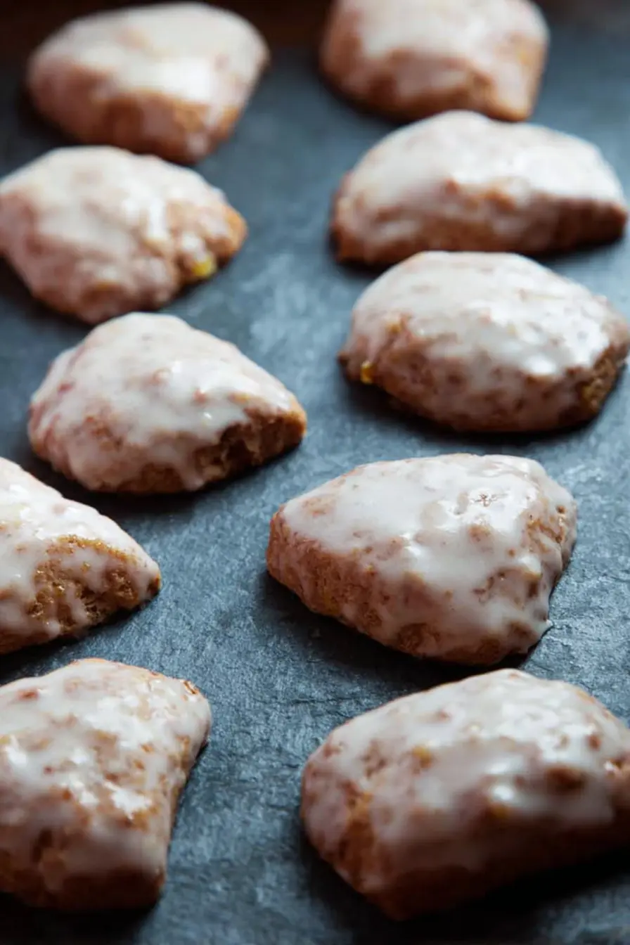 glazed orange cookies with cinnamon and cloves on dark slate