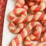 Christmas candy cane cookies with red and white twists on a white plate