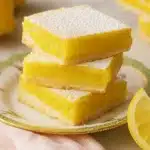 Lemon Bars Recipe | Simple, Bright & Delicious Dessert 10 Stack of lemon bars with powdered sugar on floral plate