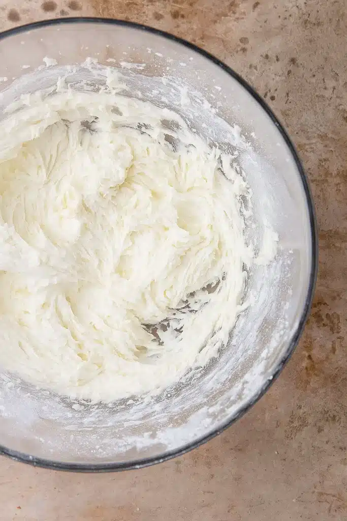 Christmas Sugar Cookie Bars – Soft, Sweet & Irresistible 15 Buttercream frosting being mixed in a glass bowl for Christmas sugar cookie bars