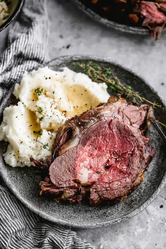 Perfect Prime Rib (Foolproof Method for Juicy, Tender Roast) 21 Sliced prime rib with mashed potatoes on gray plate