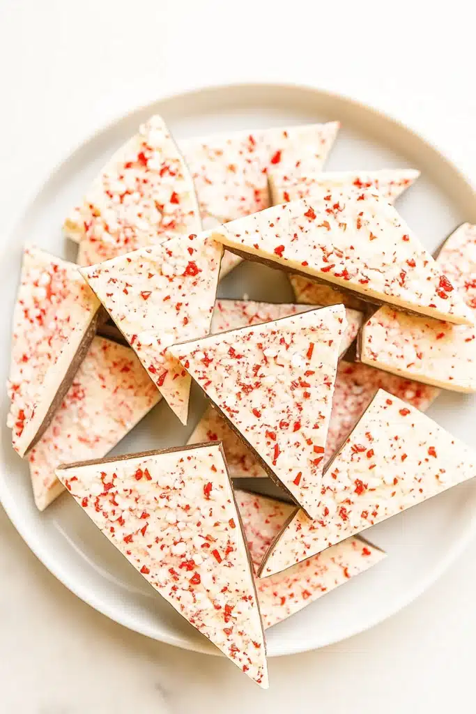 Plate of salted peppermint bark triangles topped with crushed candy canes