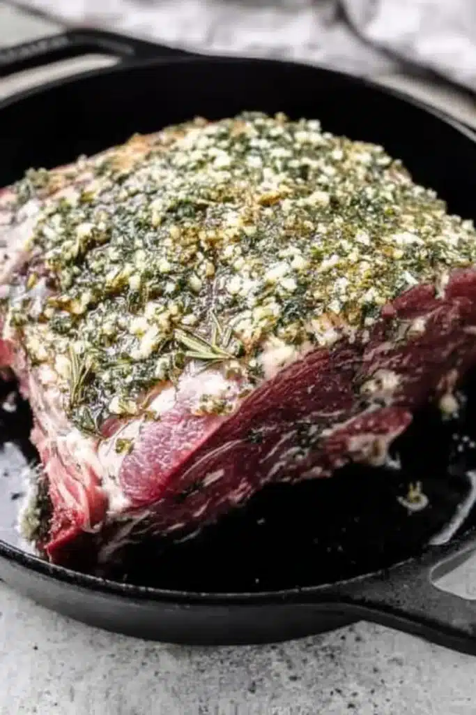 Perfect Prime Rib (Foolproof Method for Juicy, Tender Roast) 16 Seasoned prime rib roast with garlic herb butter in cast-iron skillet