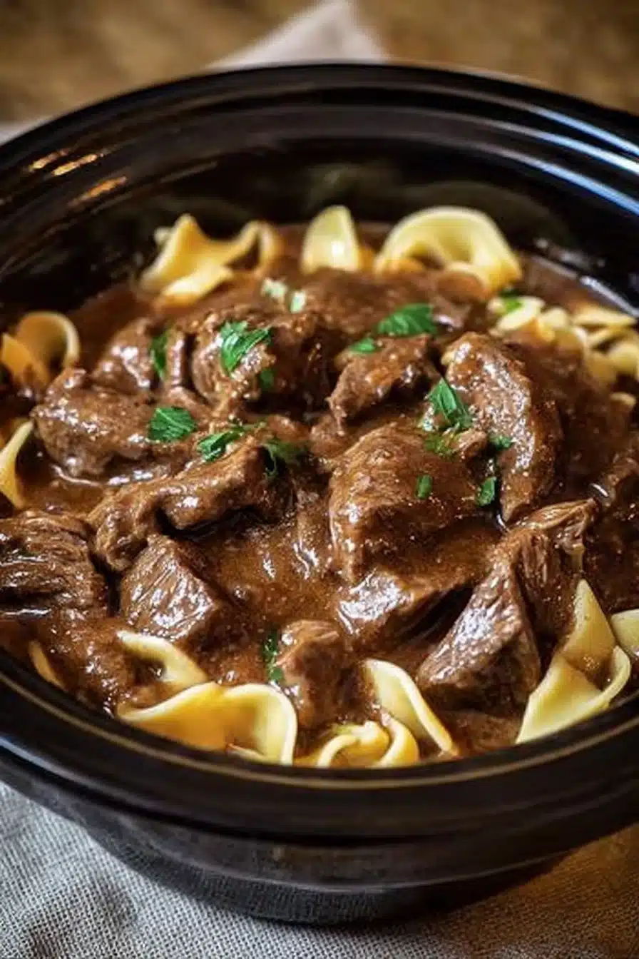 Slow Cooker Beef and Noodles in rich gravy with parsley garnish