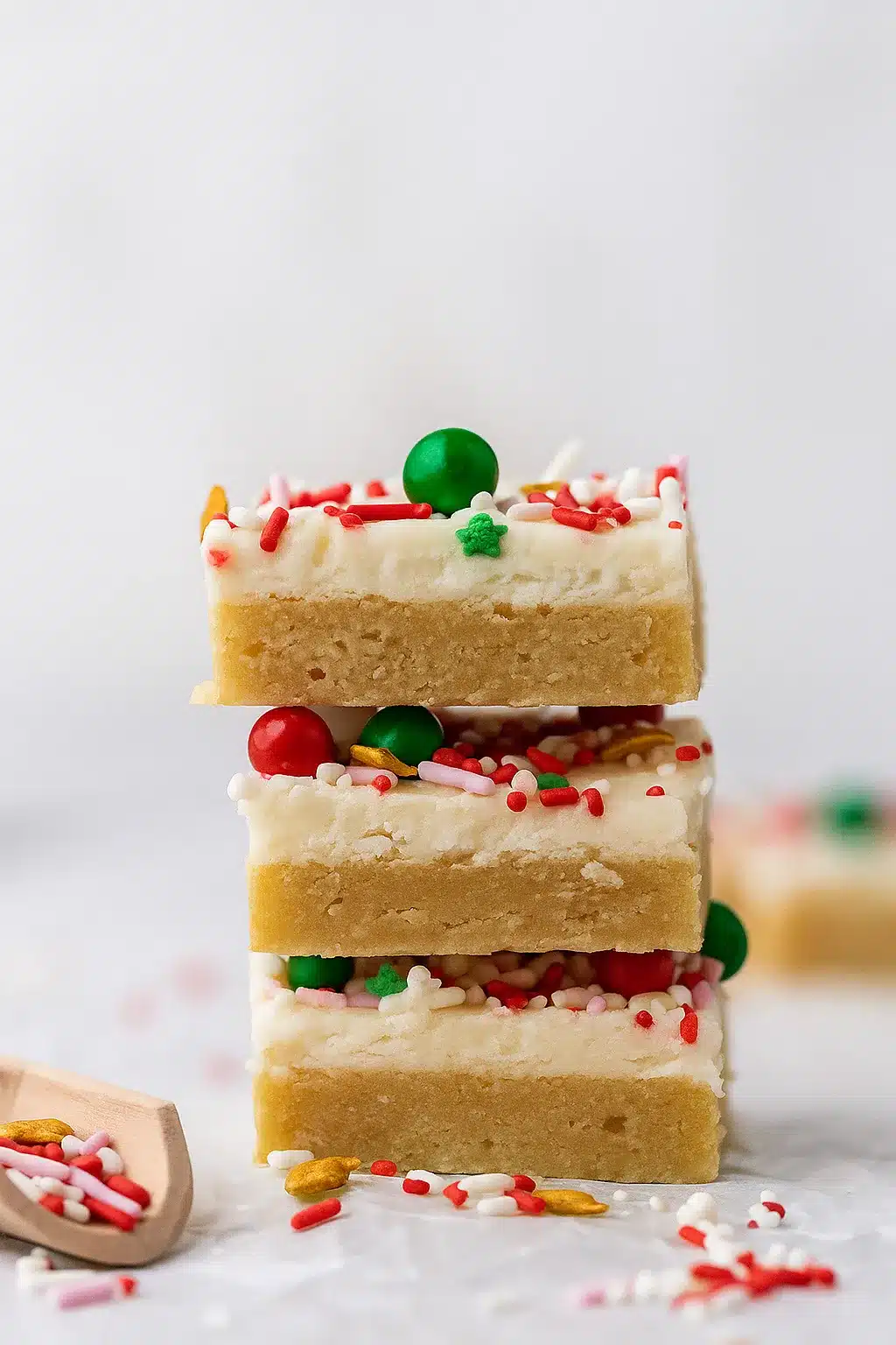 Stack of Christmas sugar cookie bars with frosting and sprinkles