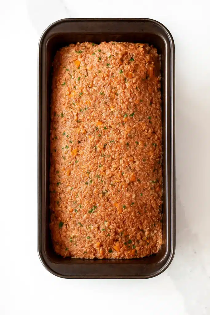 Unbaked vegetarian meatloaf mixture pressed in loaf pan