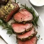 Garlic herb beef tenderloin roast sliced medium rare with creamy horseradish sauce