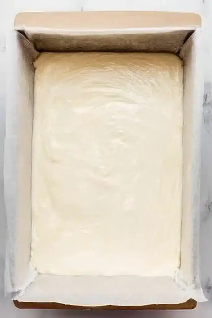 Pumpkin Cheesecake Bars | Amazing Creamy Fall Treat 19 Creamy cheesecake batter spread in a parchment-lined baking pan