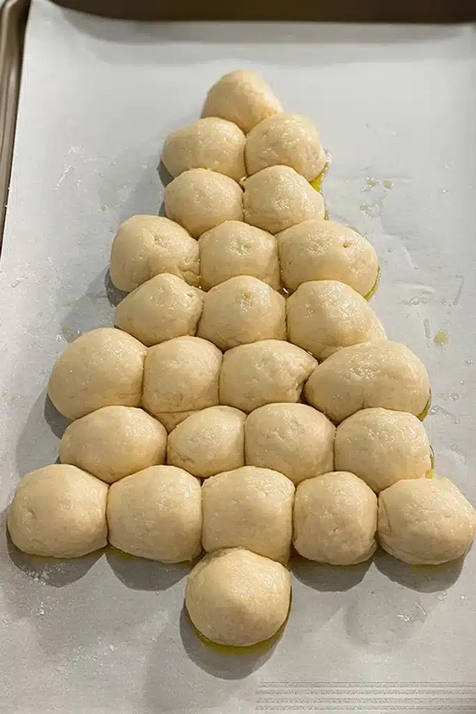 Christmas Tree Bread | Simple & Amazing Holiday Appetizer 11 Christmas tree bread dough balls arranged on a baking sheet